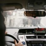 Kierowca taxi patrzy w lusterko wsteczne podczas jazdy po mieście