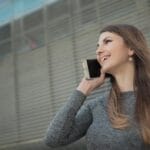 Młoda pasażerka w mieście zamawia przejazd taxi przez telefon