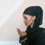 Muzułmanka w tradycyjnym stroju modli się w skupieniu