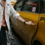 Pasażer wysiadający z taksówki zaparkowanej przy ulicy w mieście