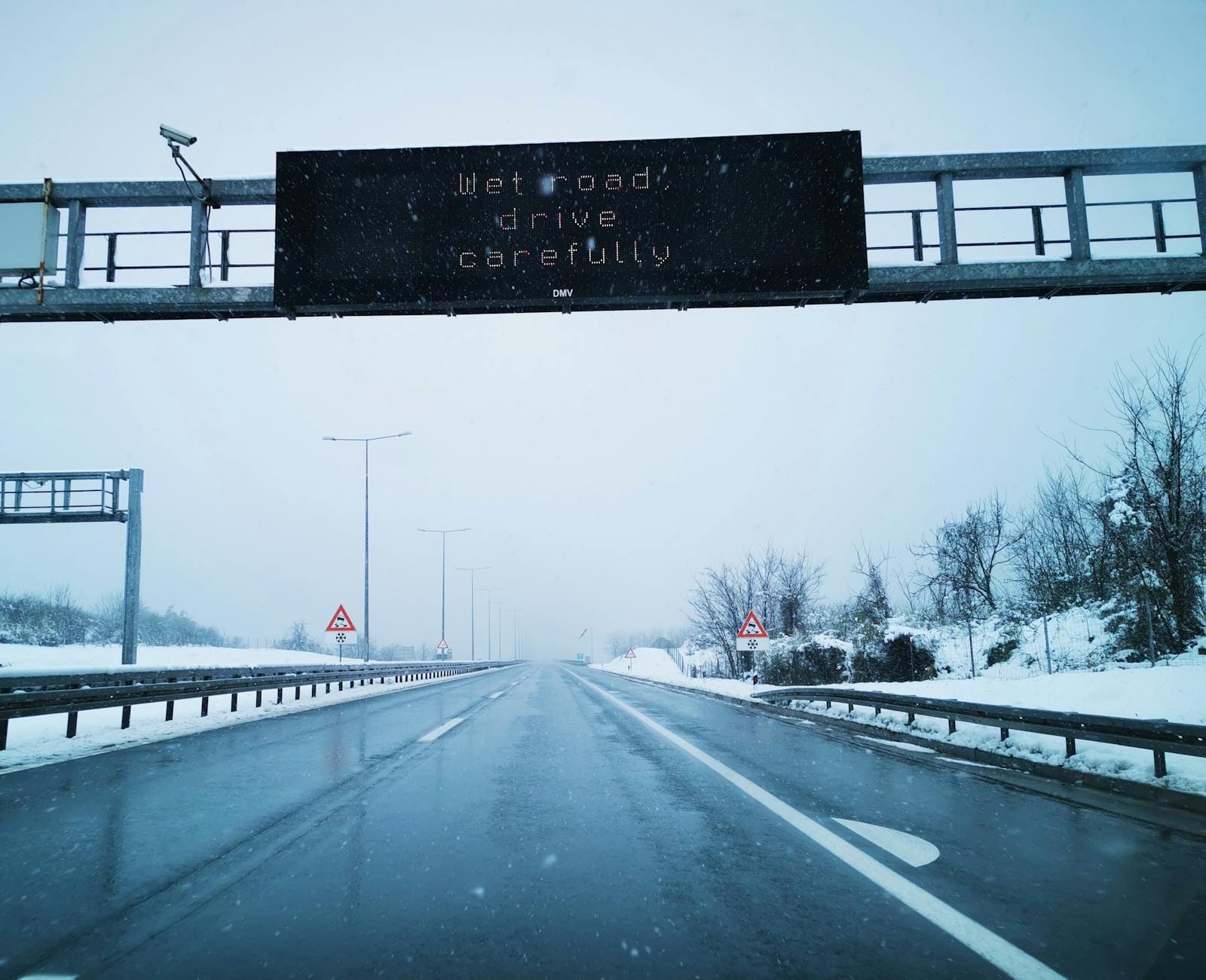 Zasypana śniegiem droga ekspresowa z znakiem ostrzegawczym