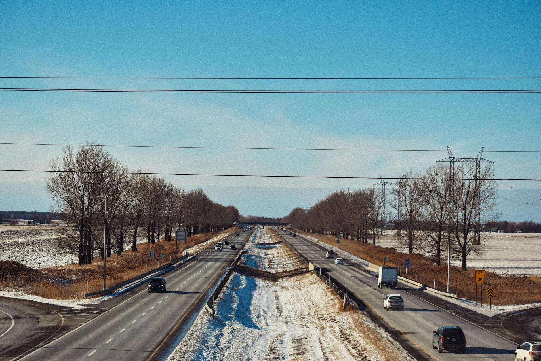 Zimowa droga ekspresowa z autami i ciężarówkami pod błękitnym niebem