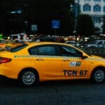 Żółta taksówka pędzi nocą przez ruchliwą ulicę miejską