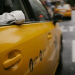 Żółta taksówka w deszczu na miejskiej ulicy