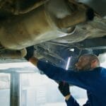 Mechanik przegląda podwozie samochodu w warsztacie samochodowym