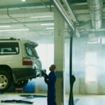 Mechanik sprawdza samochód w warsztacie podczas przeglądu układu wydechowego
