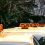 Rząd żółtych taksówek z napisem Taksi zaparkowanych przy ulicy