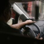 Kierowca w okularach prowadzi auto w deszczowy dzień