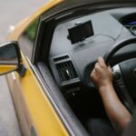 Widok z góry na kierowcę żółtej taksówki z nawigacją GPS